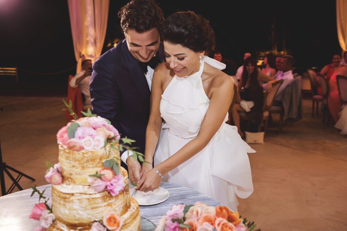 Bride and groom cut cake at wedding in Riviera Maya