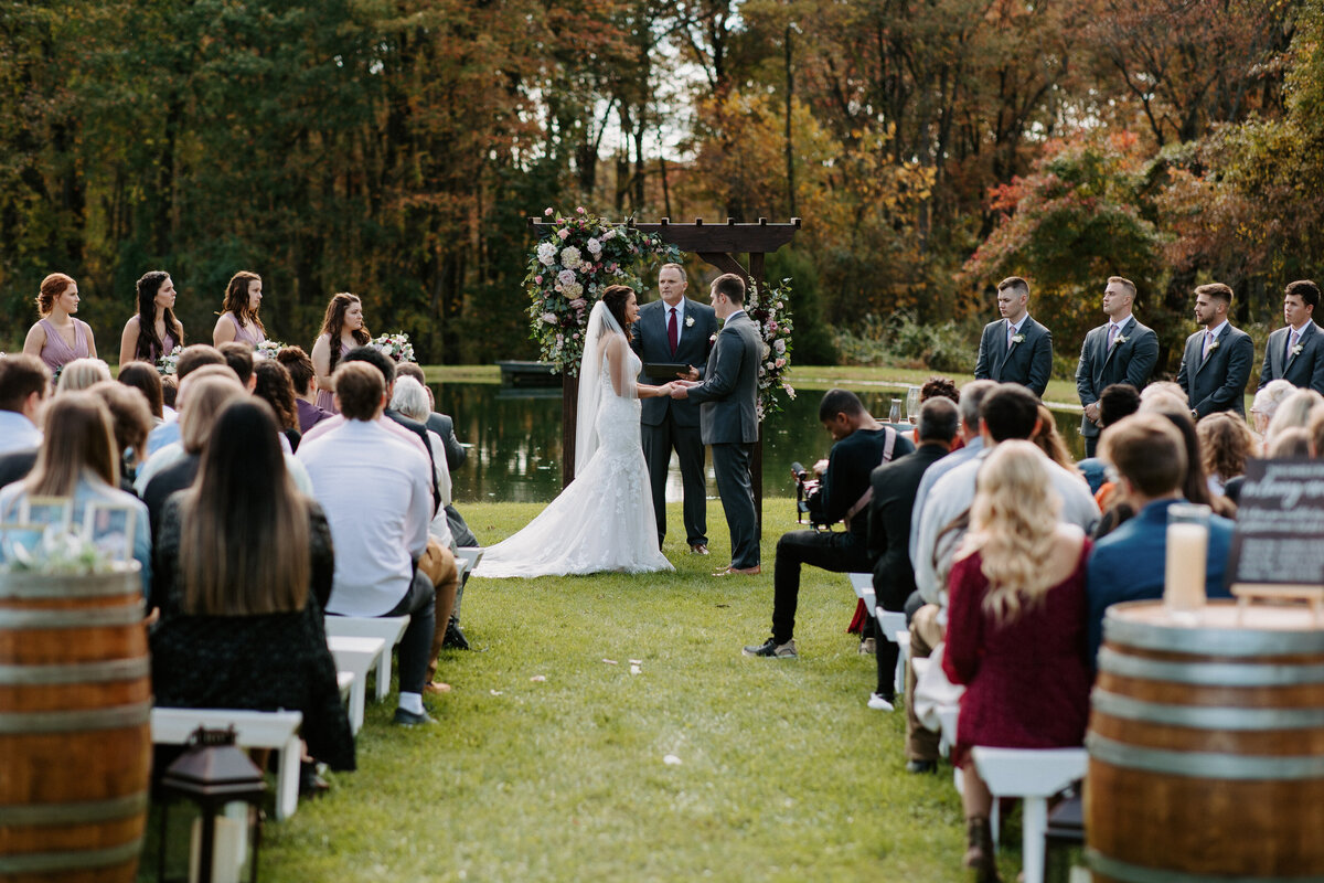 view from the end of an aisle of a couple standing up at the alter with guests sitting on either side