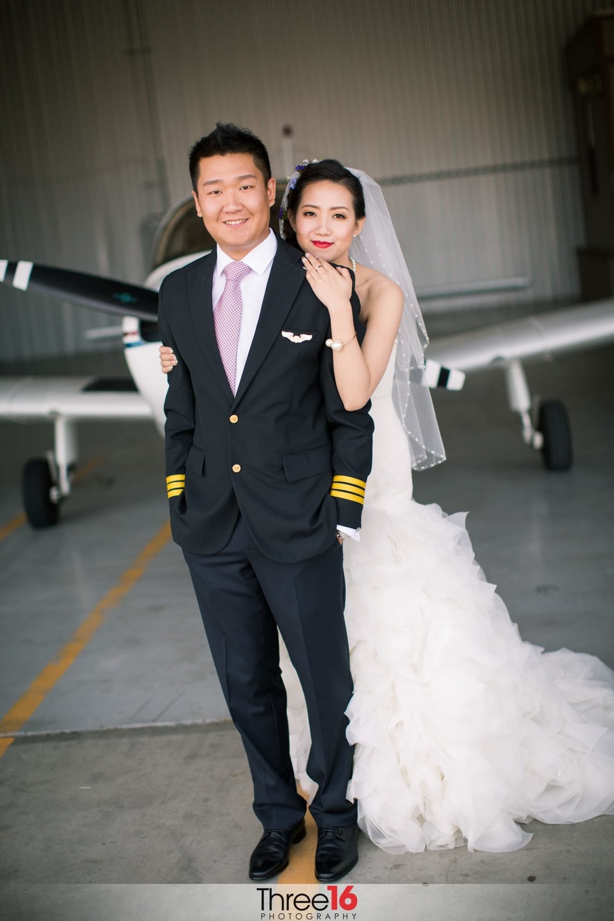 Bride and her Groom pose in front of small aircraft