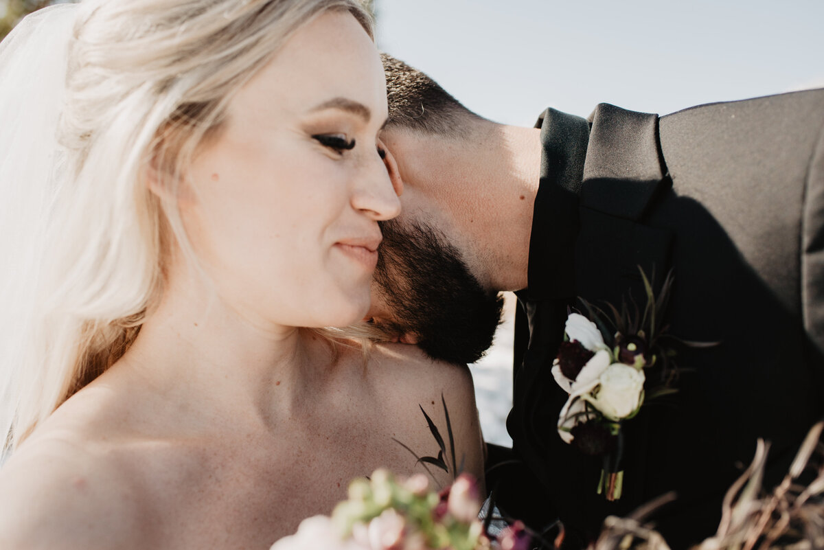 Jackson Hole Photographers capture groom kissing bride's shoulder