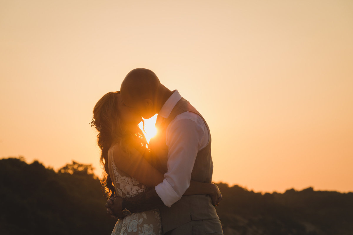 photo of bride and groom kissing during beach sunset wedding at Pavilion at Sunken Meadow