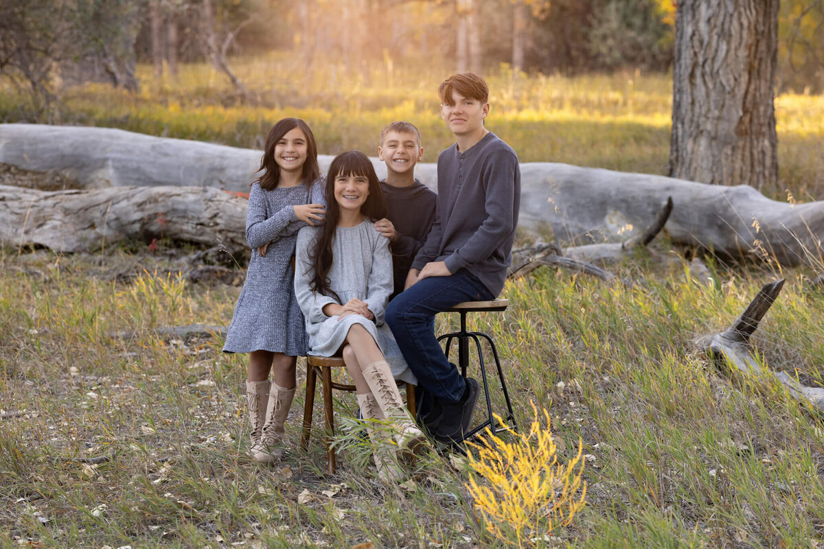 four siblings standing together in a field