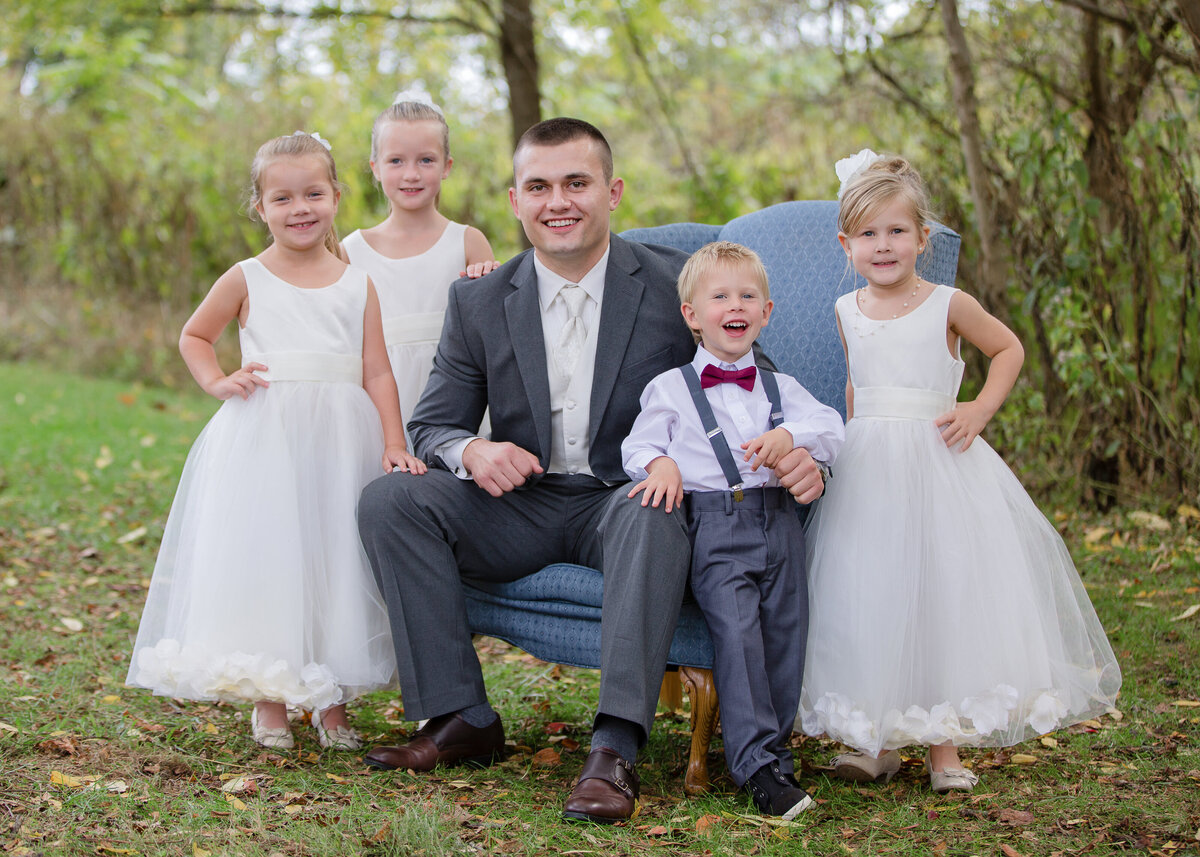 groom with flower girls and ring bearer