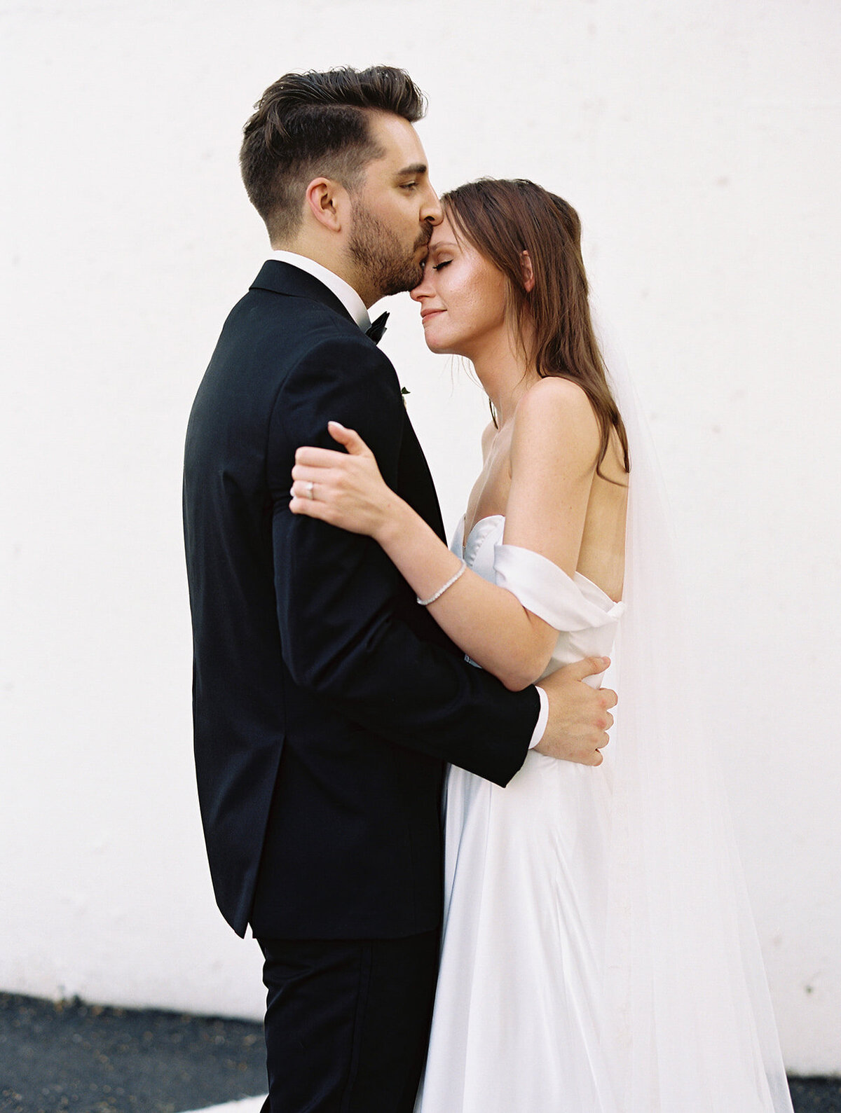 groom-kissing-bride-forehead