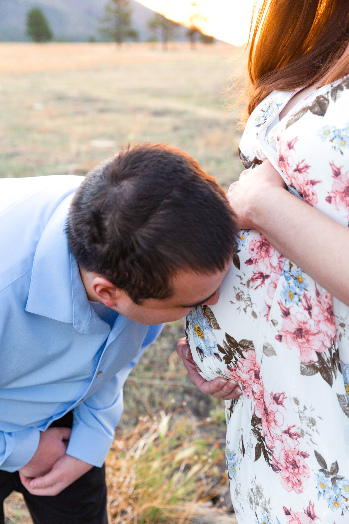 Expectant father kisses wife's tummy during a maternity portrait session in Flagstaff, Arizona