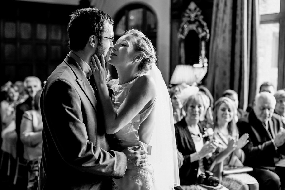 Bride & Groom having first kiss in black and white wedding photo at Huntsham Court