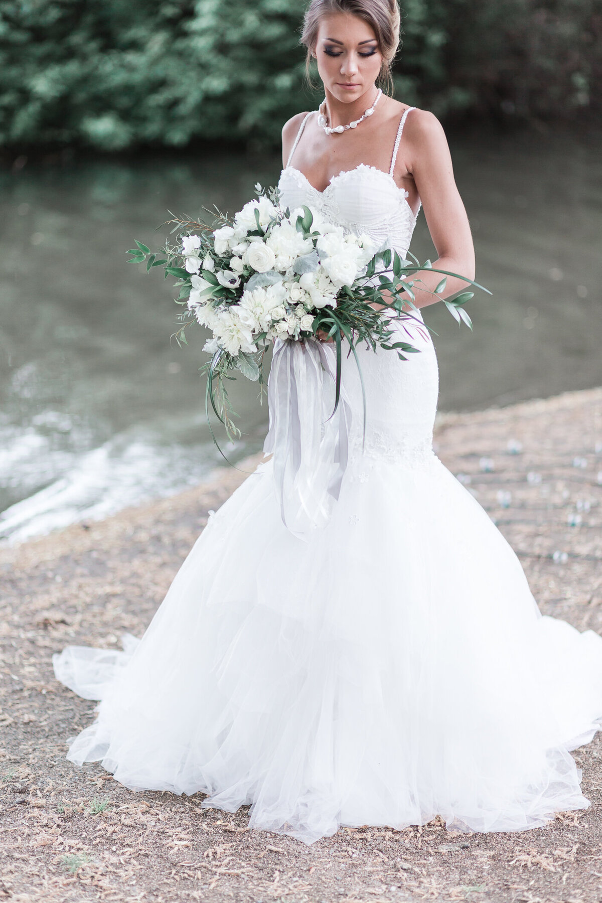Kaloya Park Okanagan Bride by the water in couture gown with floral bouquet