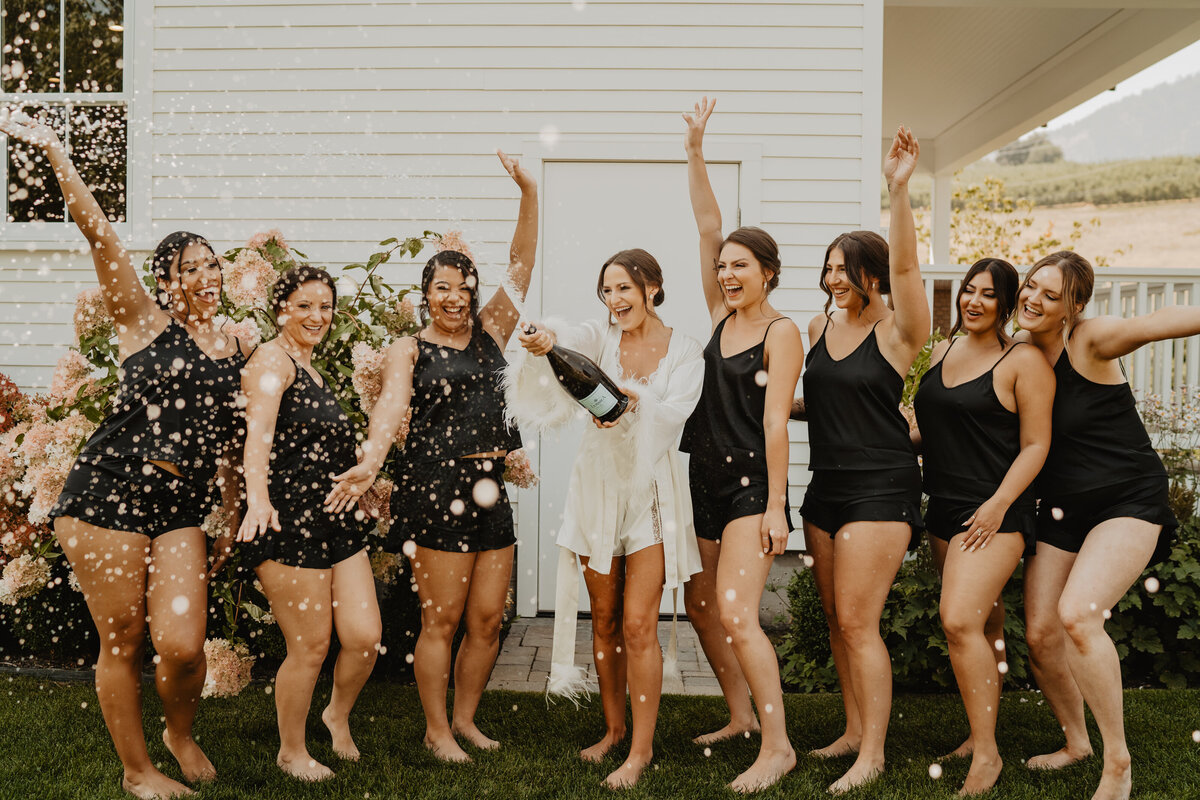 bridesmaids popping champagne