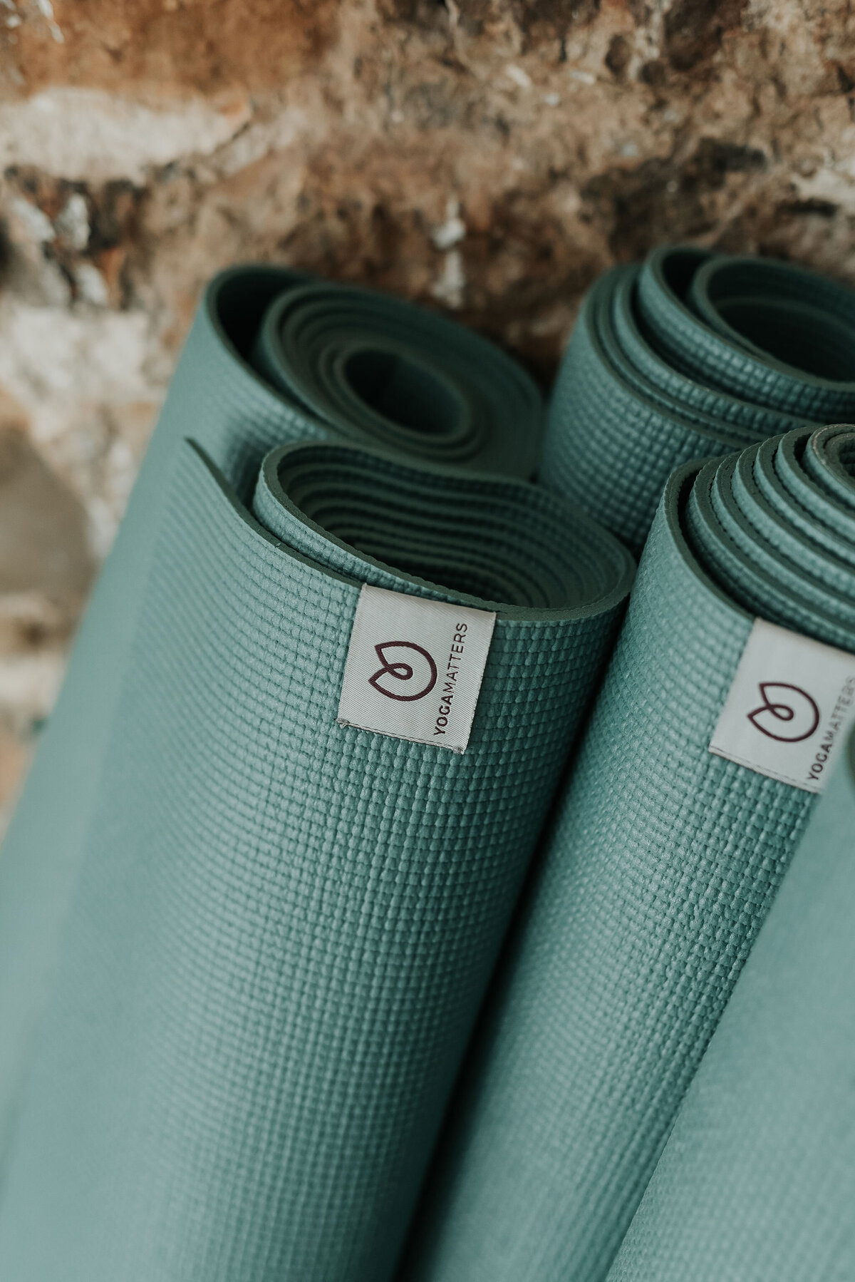 Close up of pale green rolled up pilates exercise mats