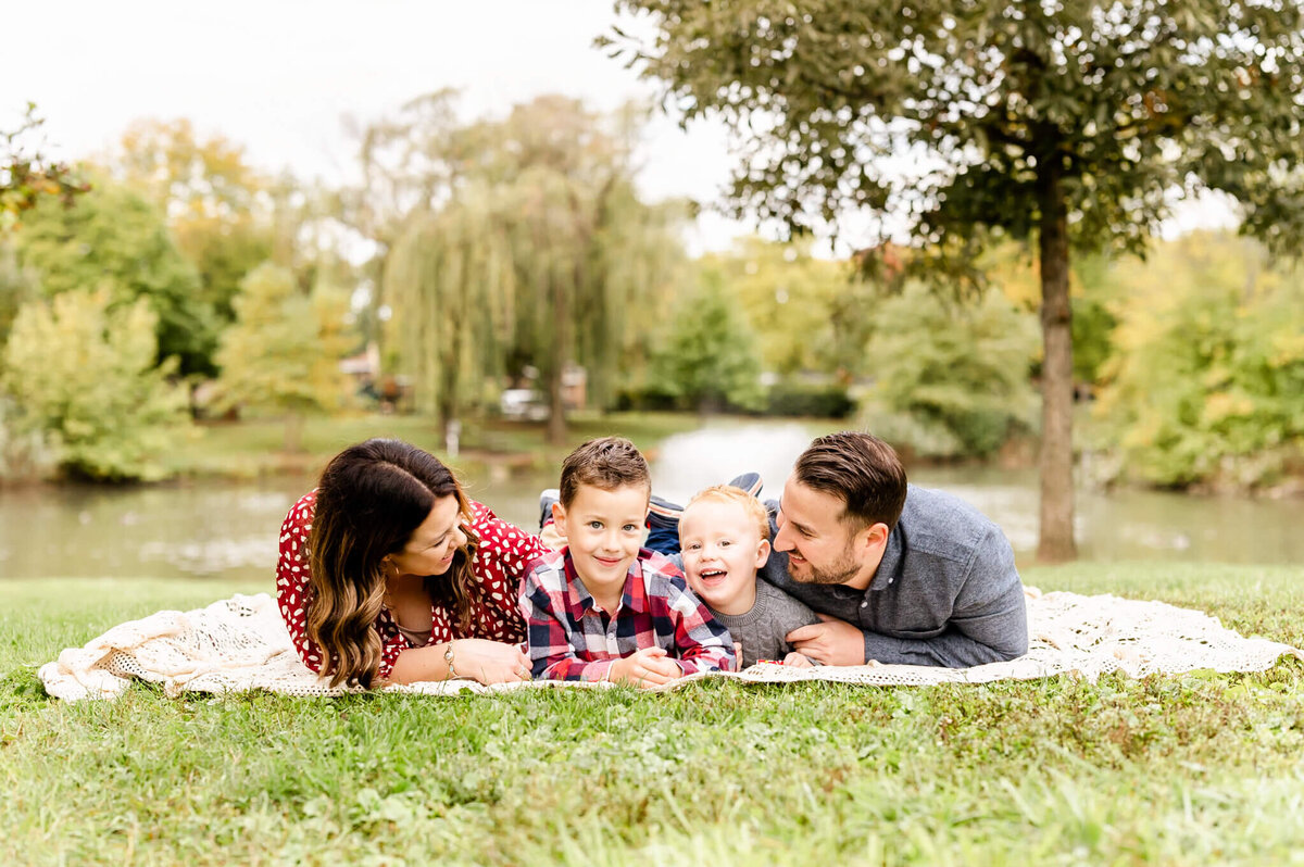 Lad back family laughing on blanket at session with Naperville family photographer.