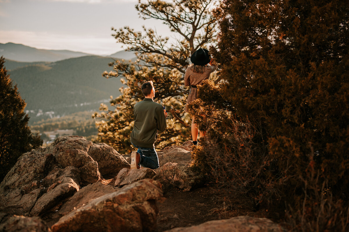 man proposes to girl on top of mountain in mt falcon colorado for a proposal session