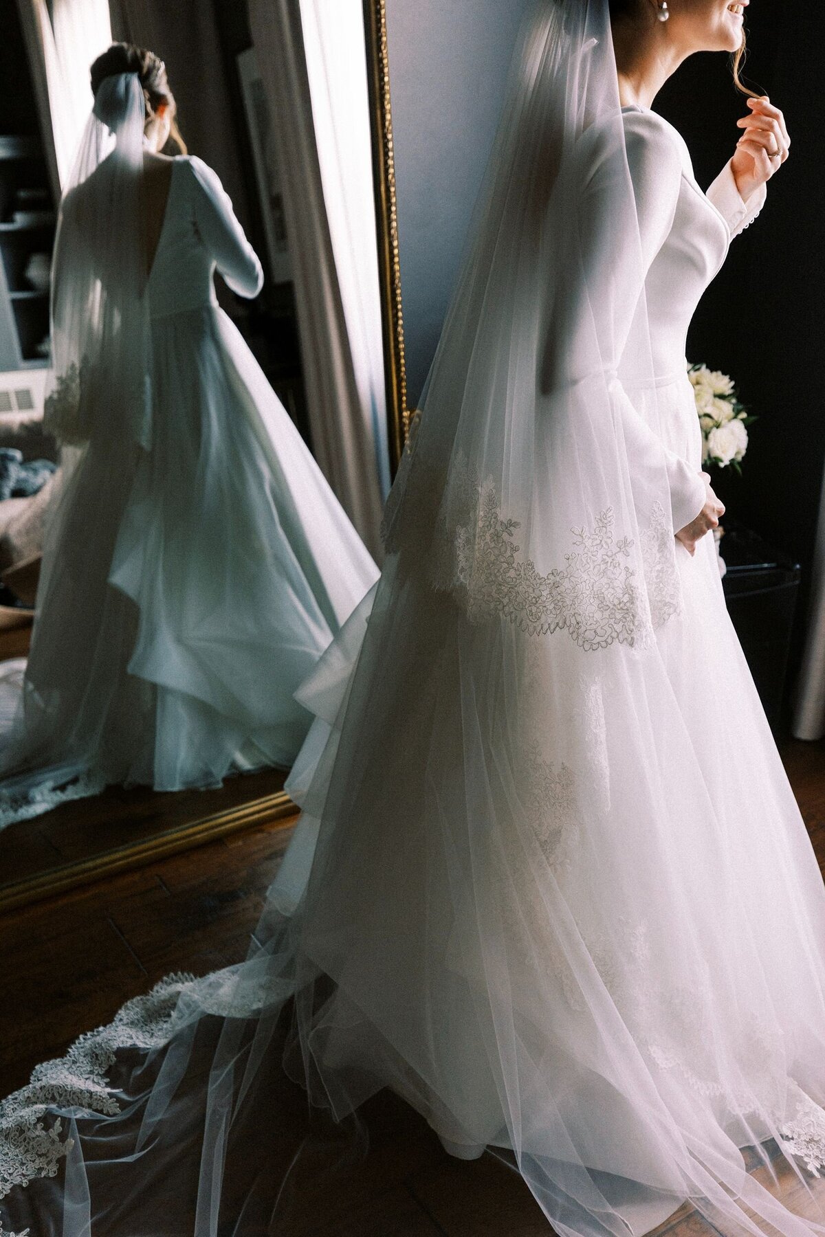 Bride getting dressed with tall mirror