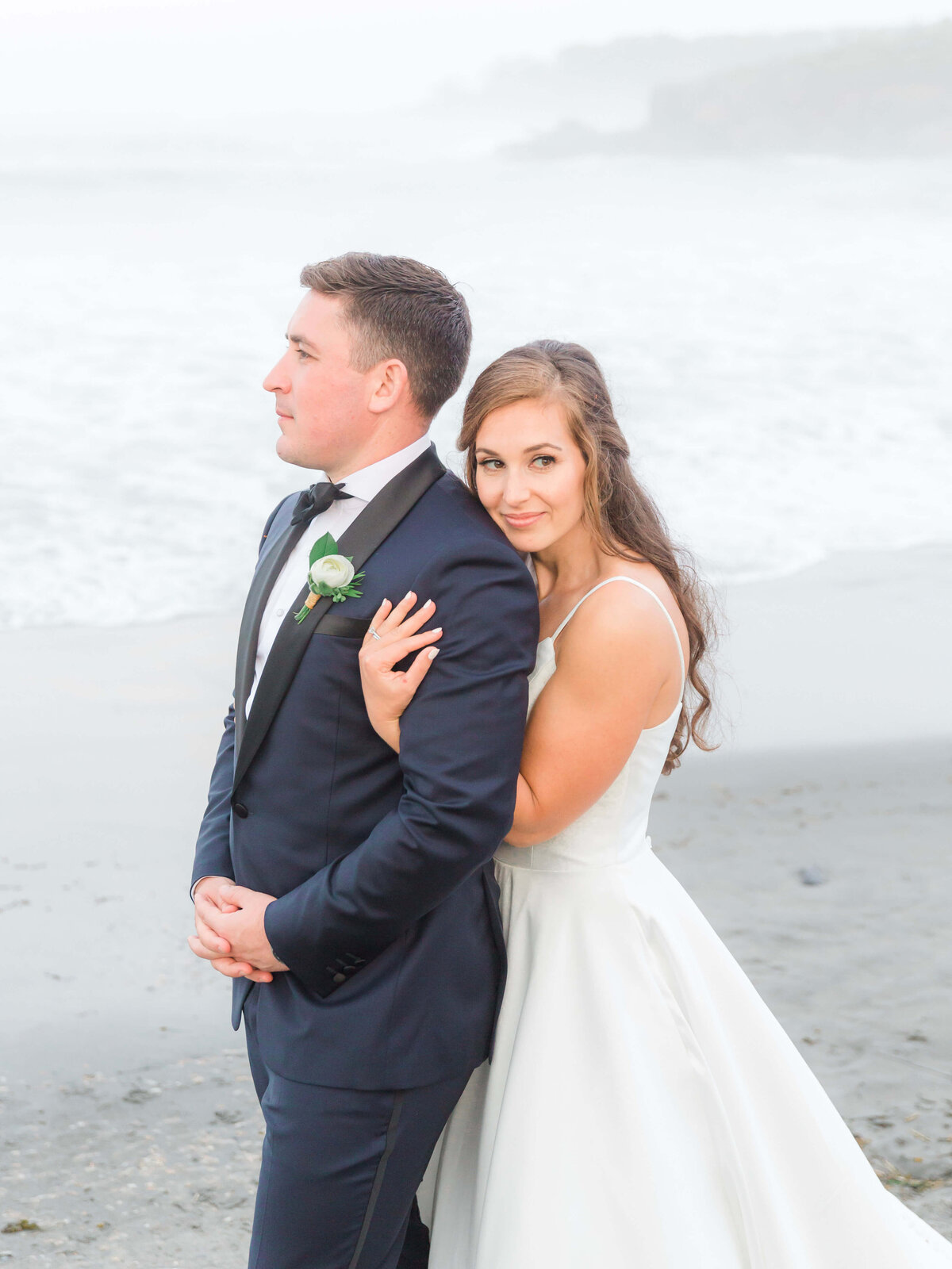 adventurous bride and groom standing on rocks at York Harbor beach for york Inn Wedding  (30)