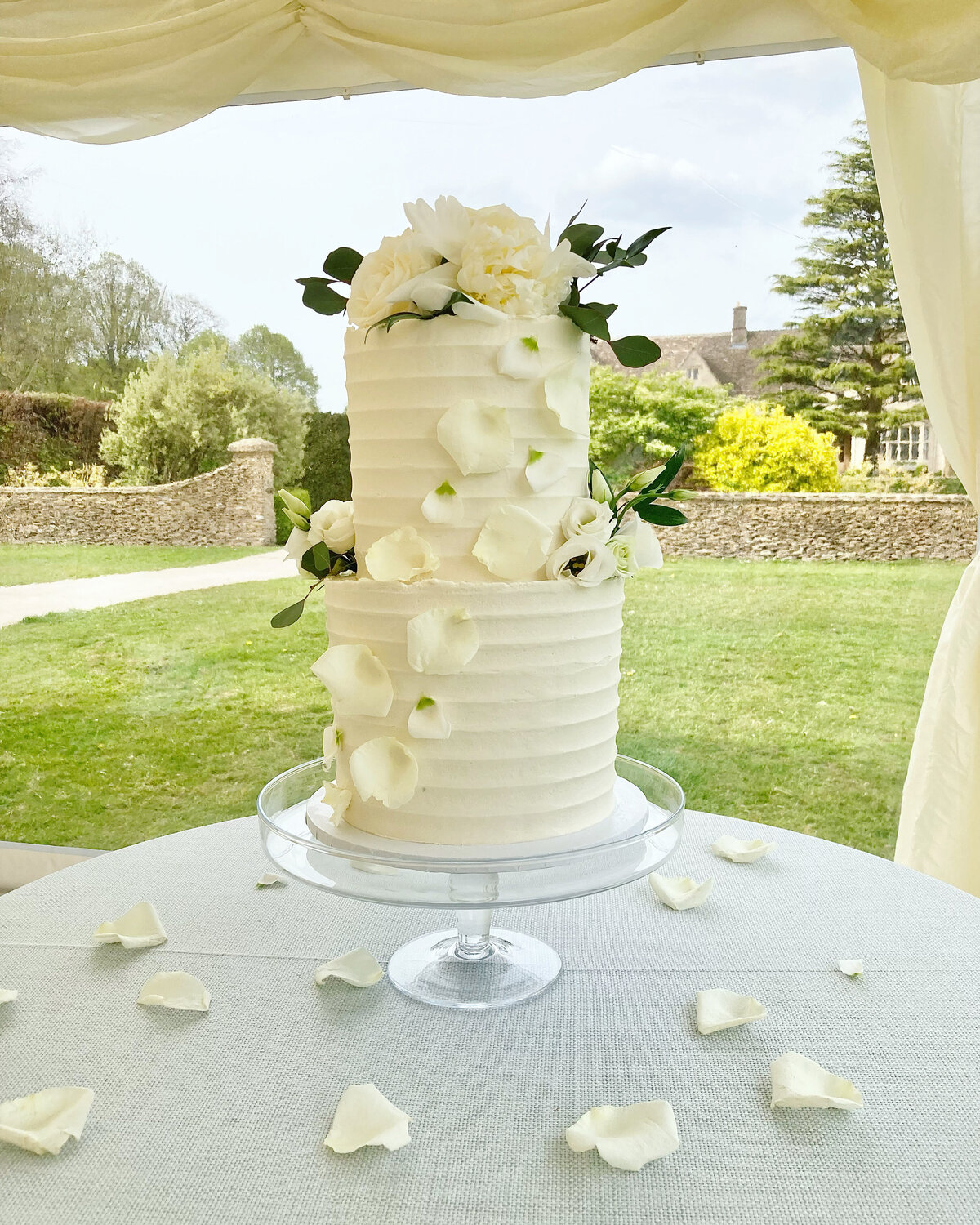 2 tier textured buttercream wedding cake with roses and petal cascade
