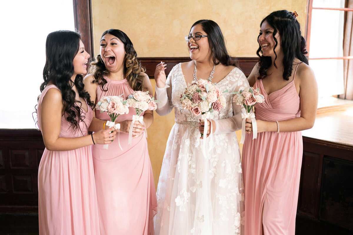 Bride laughs with bridesmaids.