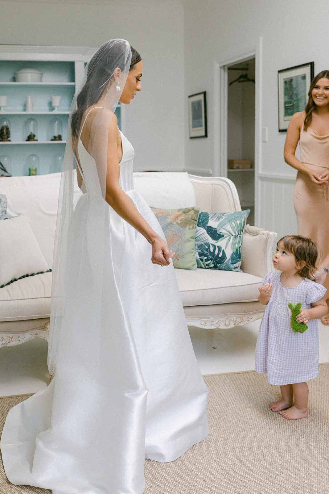 bride getting ready with her flower girl