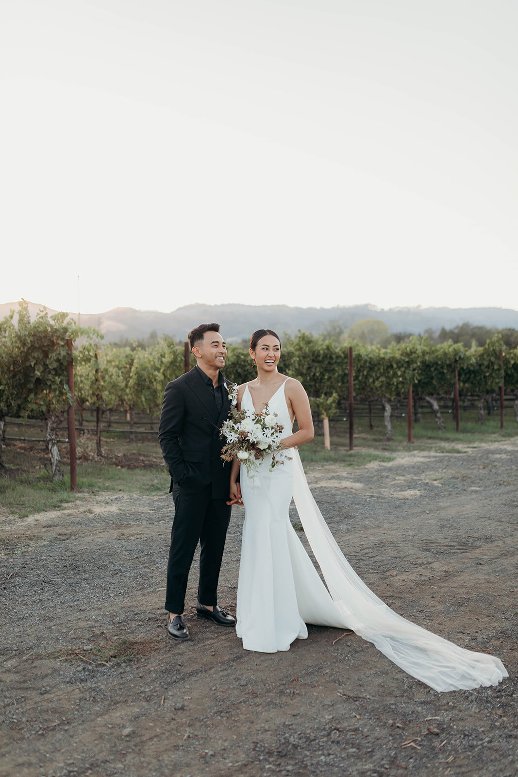 Groom and bride posing in vineyard venue