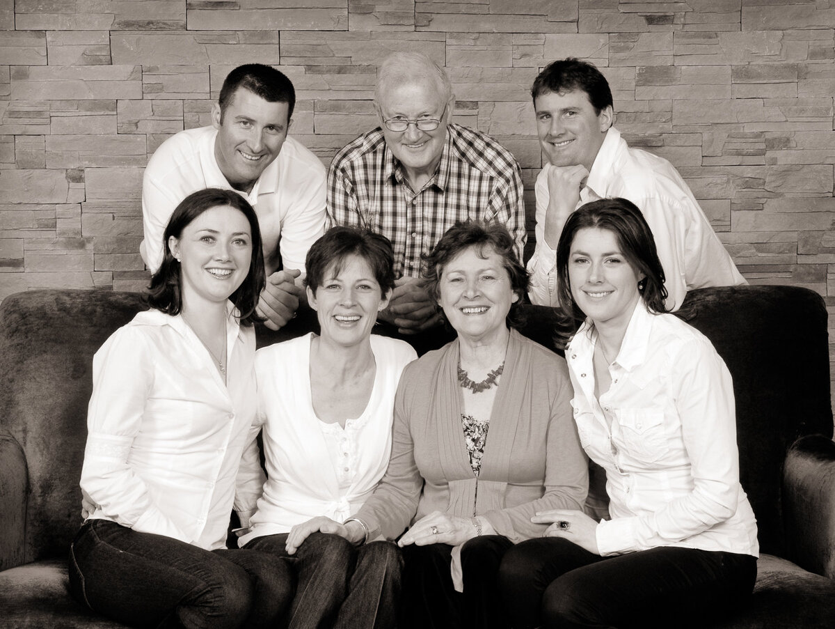 black & white portrait of grown up family of seven wearing white tops