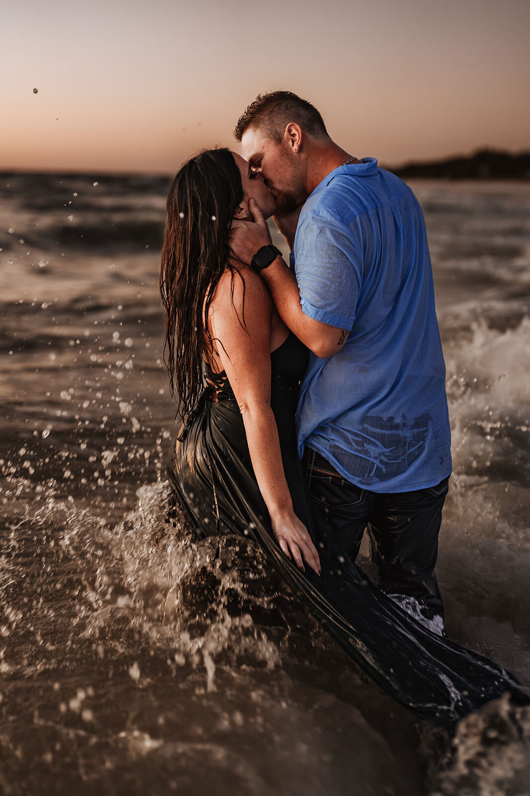 couple in the ocean at coquina beach during engagement session