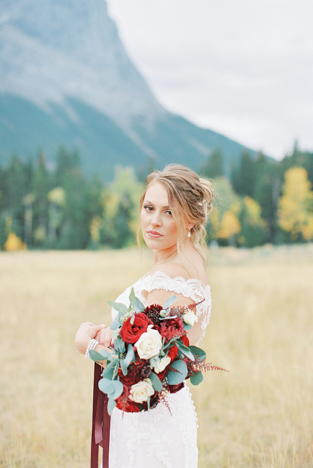 bride holding flowers in the mountains