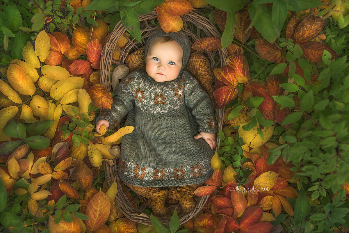 Baby laying in autumn leaves. Brilliant autumn leaves.