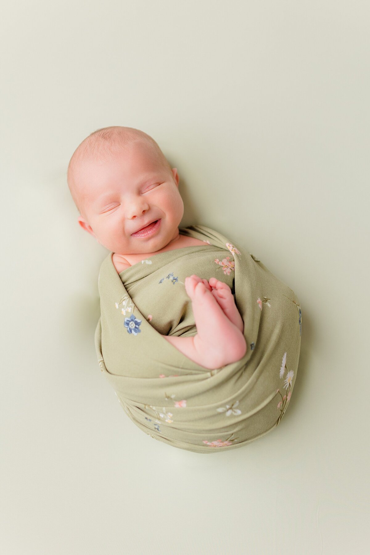 newborn baby in sage wrap
