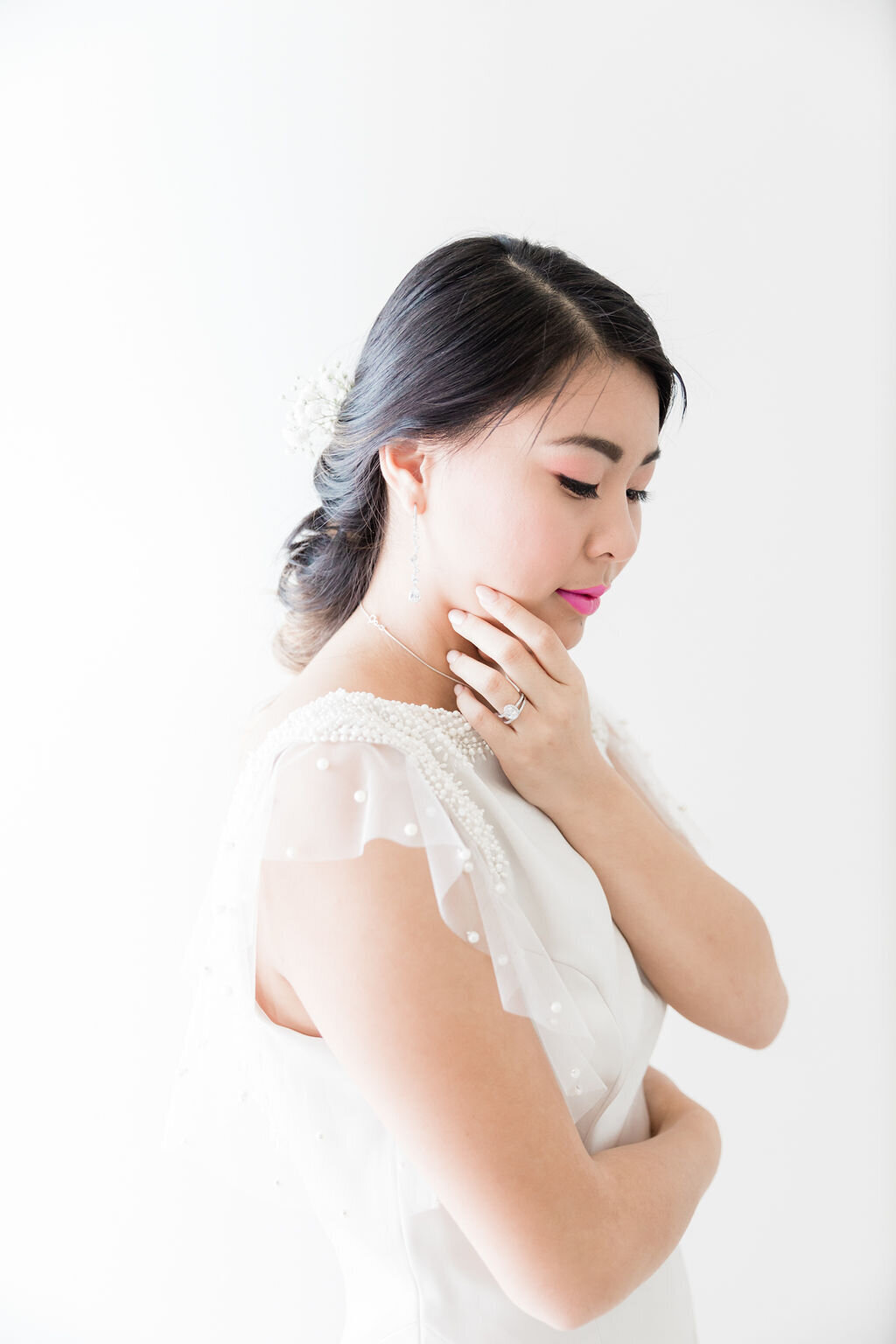 Bespoke pearl beading trims the pearl net tulle flutter sleeves on the Hana wedding dress style.