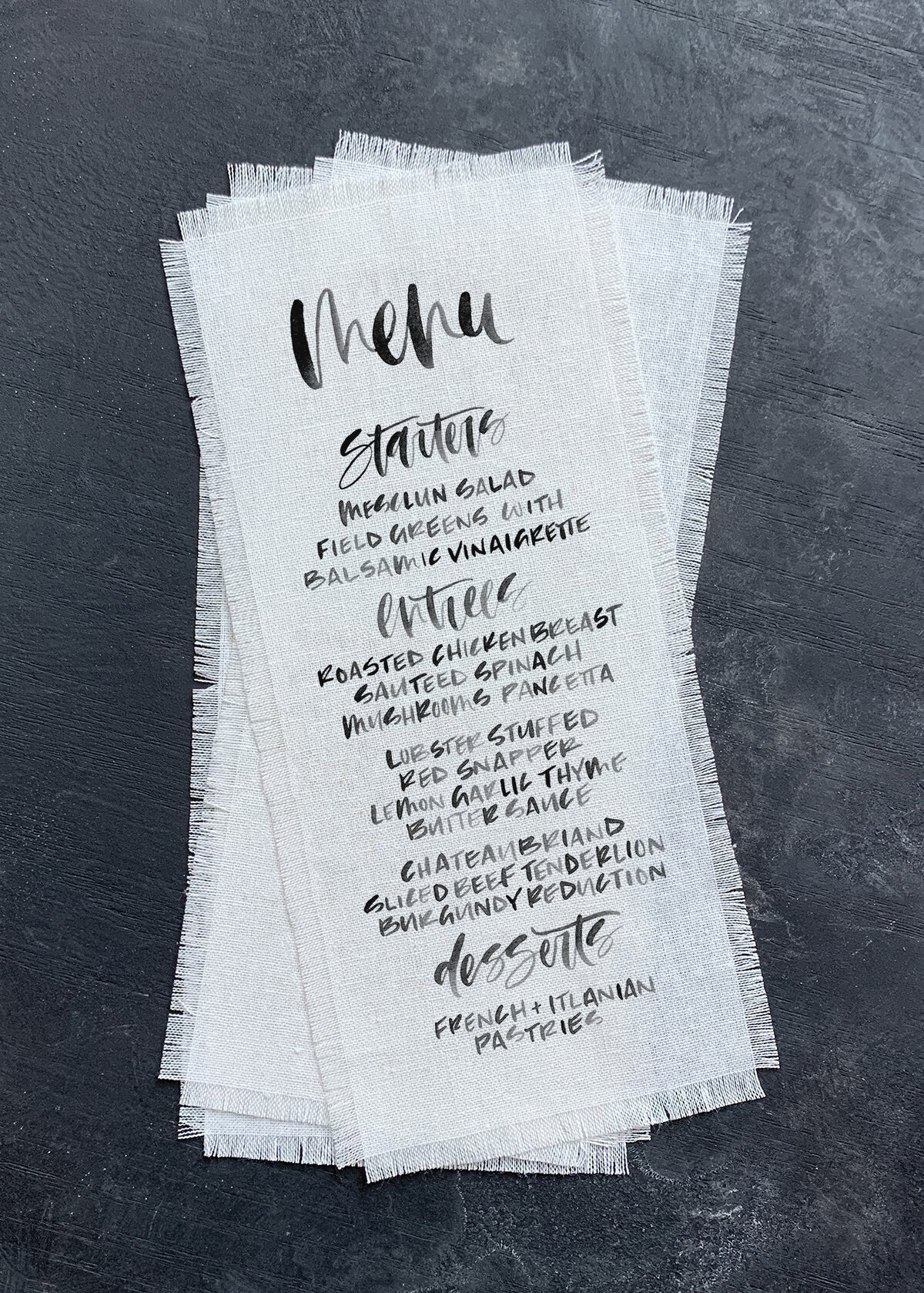 calliigraphy on fabroc printed linen wedding menus.