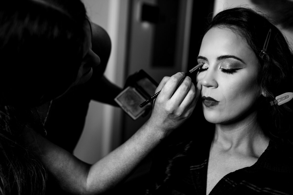 Black-and-white-image-of-bride-getting-makeup-done-getting-ready-for-her-wedding
