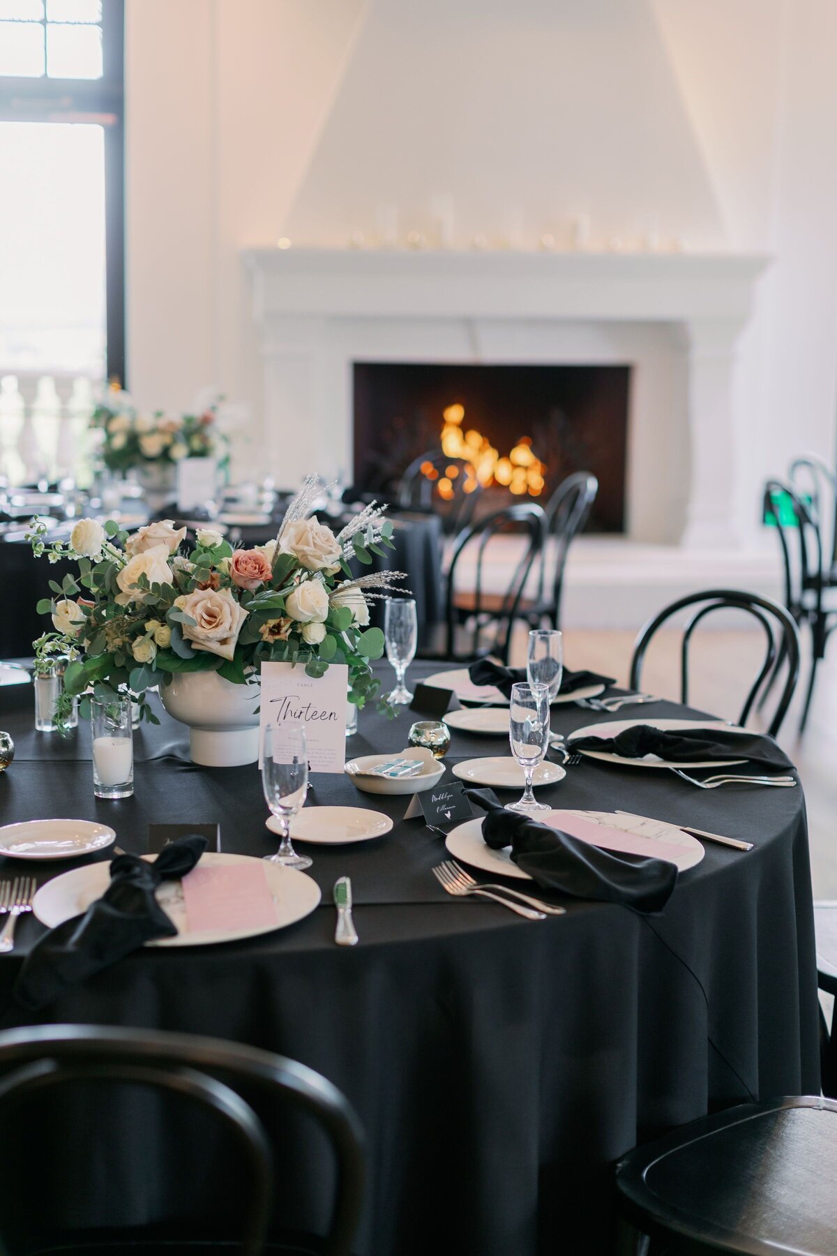 Bouquets with a hint of color sit in the center of each dining table to offset black and white.