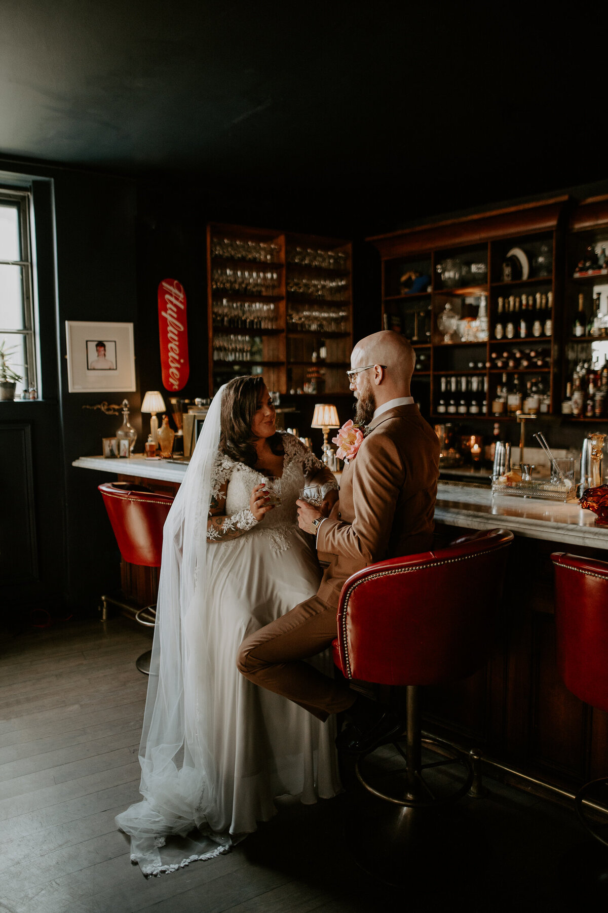 A couple are drinking at the bar at their wedding at FiveFourStudios in Salford / Manchester.