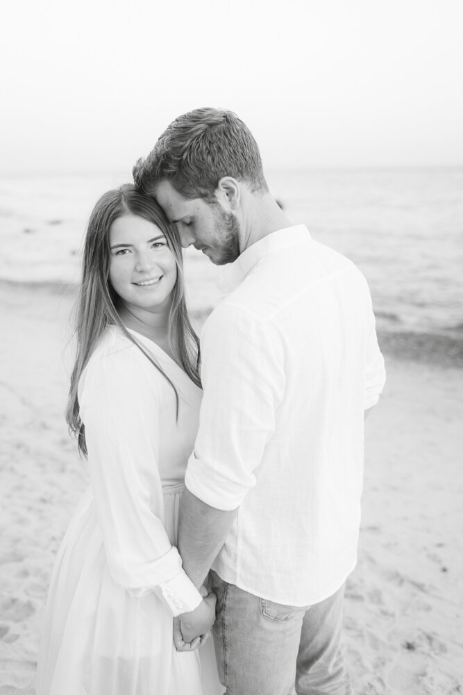 black and white engagement portrait of couple on the beach