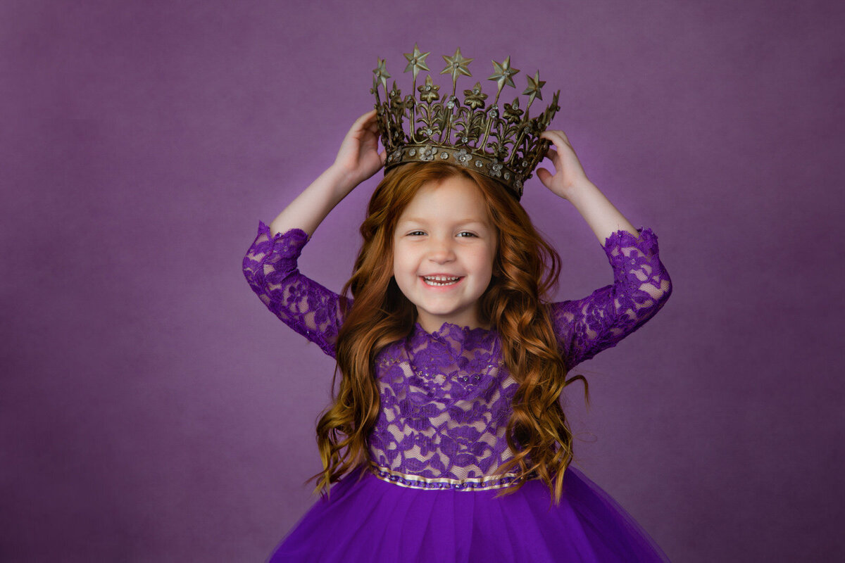 girl-in-purple-holding-crown-in-studio