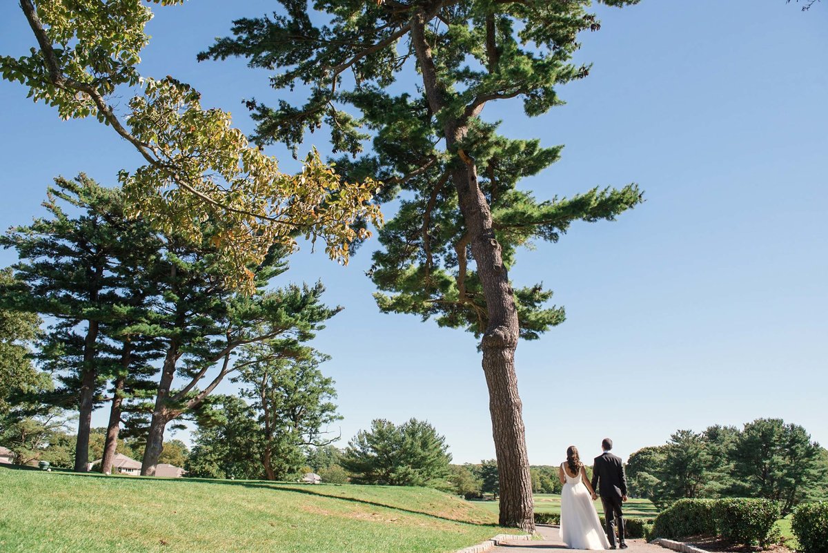 Bride and groom walking away in outdoor area at Stonebridge Country Club