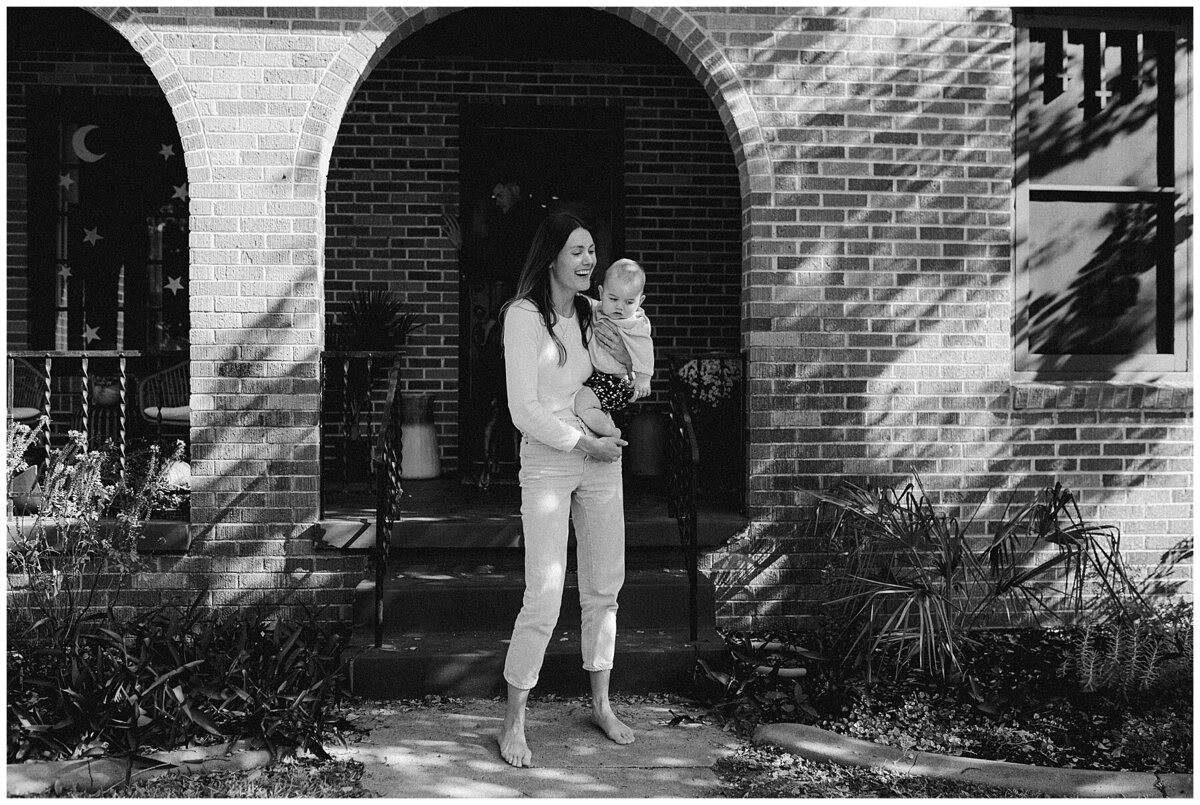 Woman holding baby outside of Austin home at sweet home family session in Austin by Amber Vickey Photography