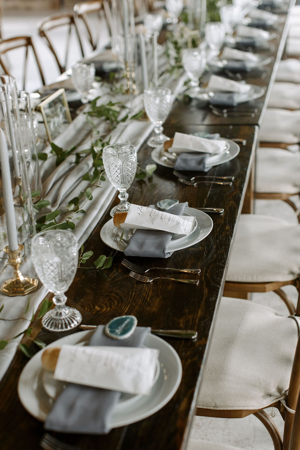 Wedding reception table scape with gray napkins and greenery