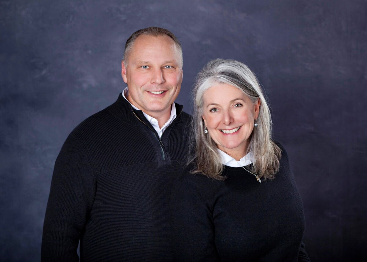 Team Gary and Teresa Bilben Real Estate Agents Headshots on a gray backdrop.