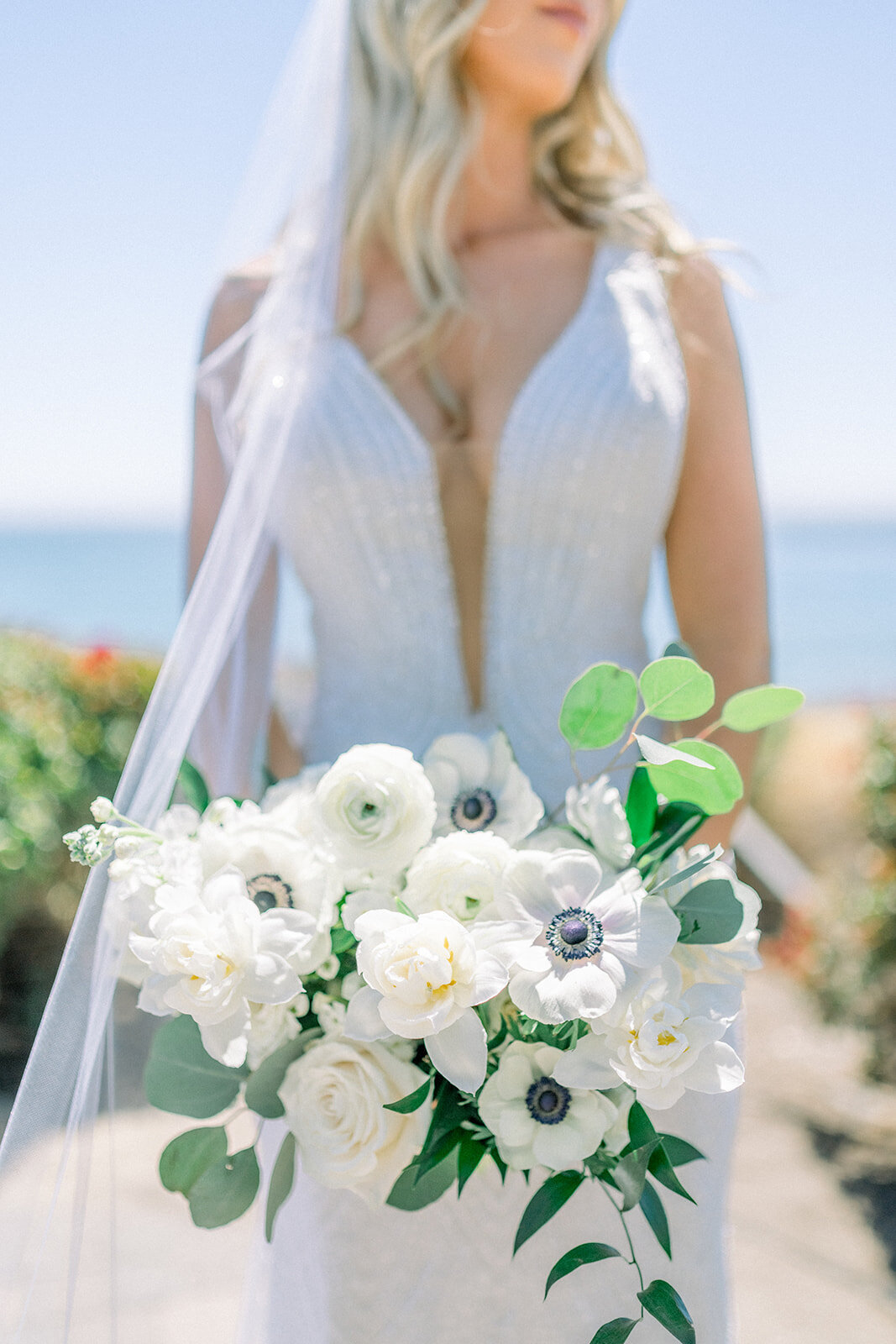 Bride holding White wedding boquet at Dolphin Bay Resort in Pismo Beach, CA