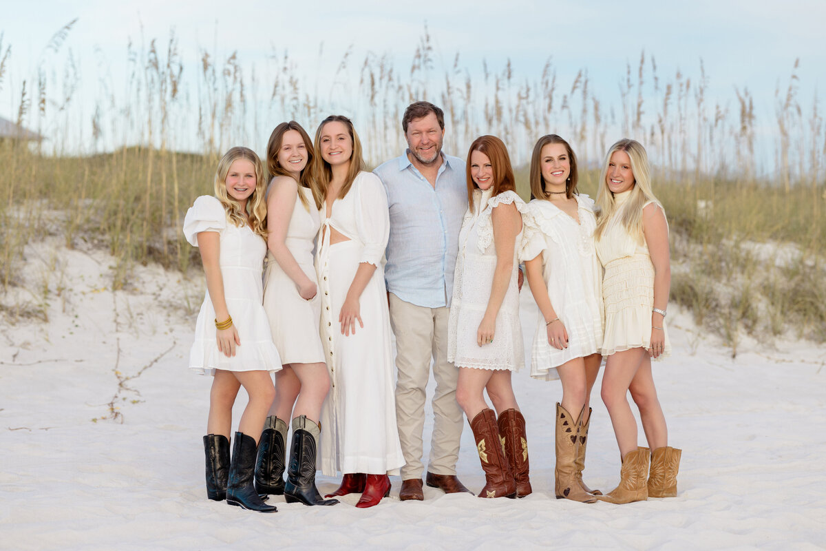 A family in cowboy boots standing together at the beach