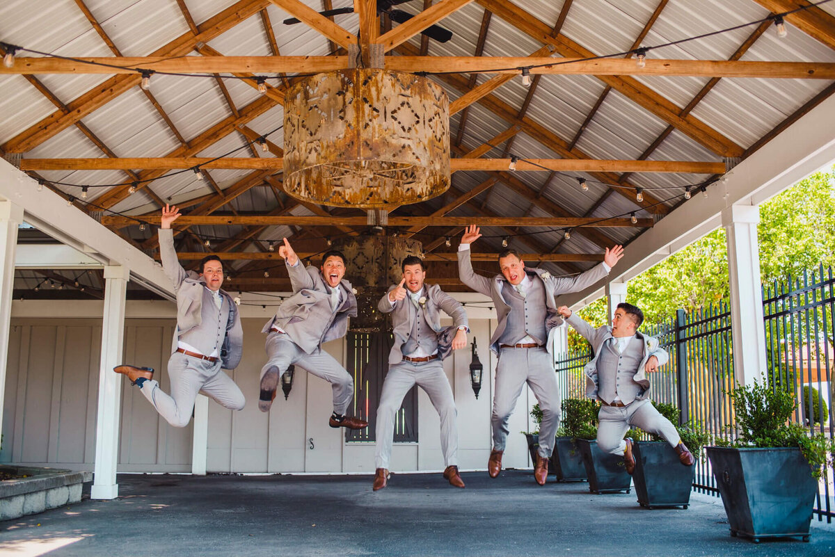 photo a groomsman jumping up and celebrating before their Tennessee wedding