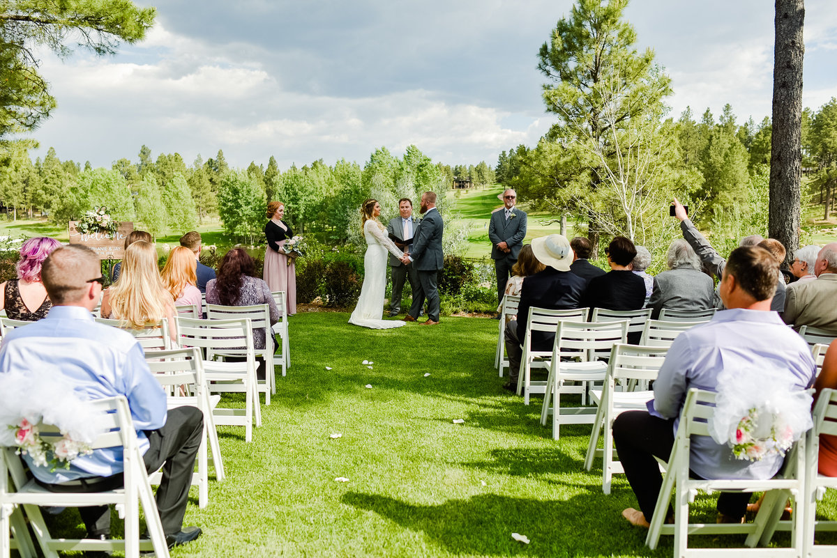 Bride and Groom standing holding hands at wedding ceremony at Pine Canyon Golf Club Flagstaff wedding