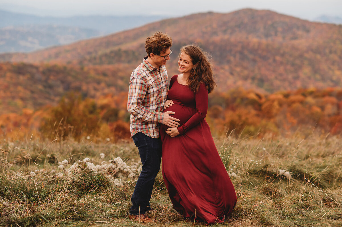 Expectant parents embrace during Family Photoshoot at Max Patch in Asheville, NC.