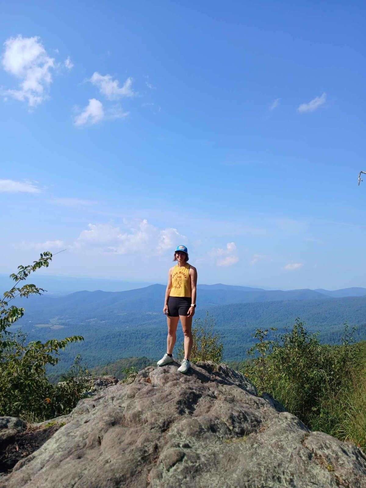 Aimee, an elopement photographer stands on the top of Bear Fence Summit in Shenandoah National Park
