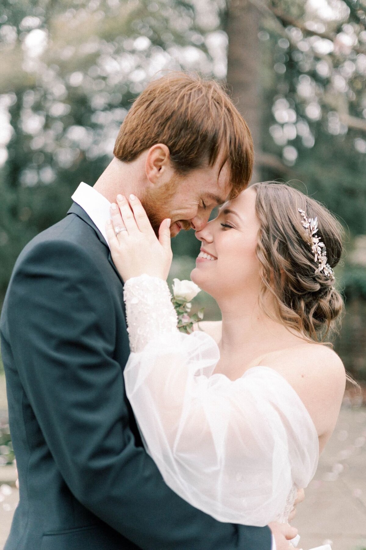 Bride and groom smiling touching noses.