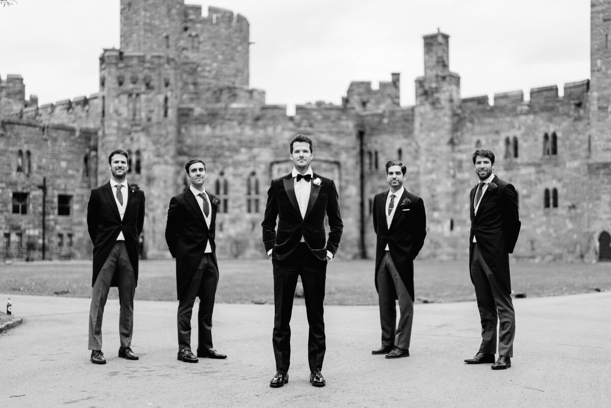 groomsmen stood outside peckforton castle in fashion style