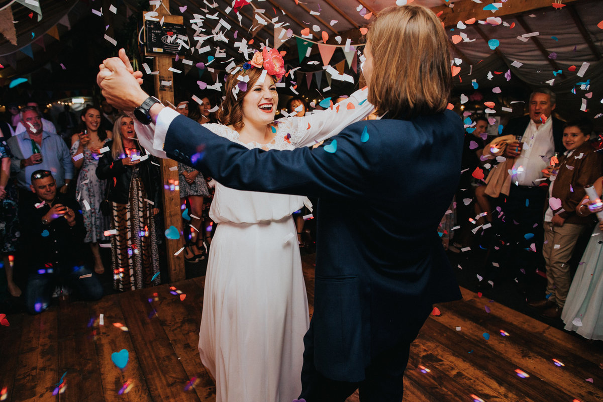Couple surprised by confetti canon during first dance