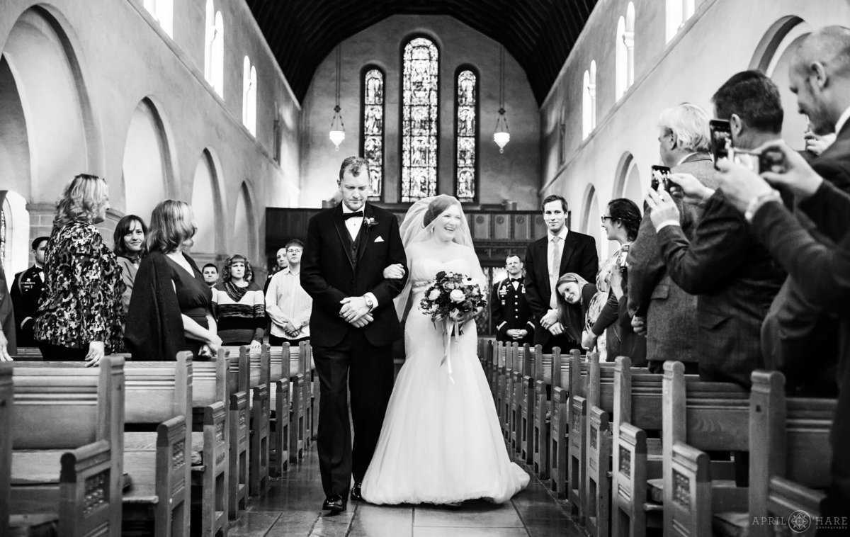 Beautiful B&W photo of bride walking down aisle at Shove Chapel in Colorado Springs