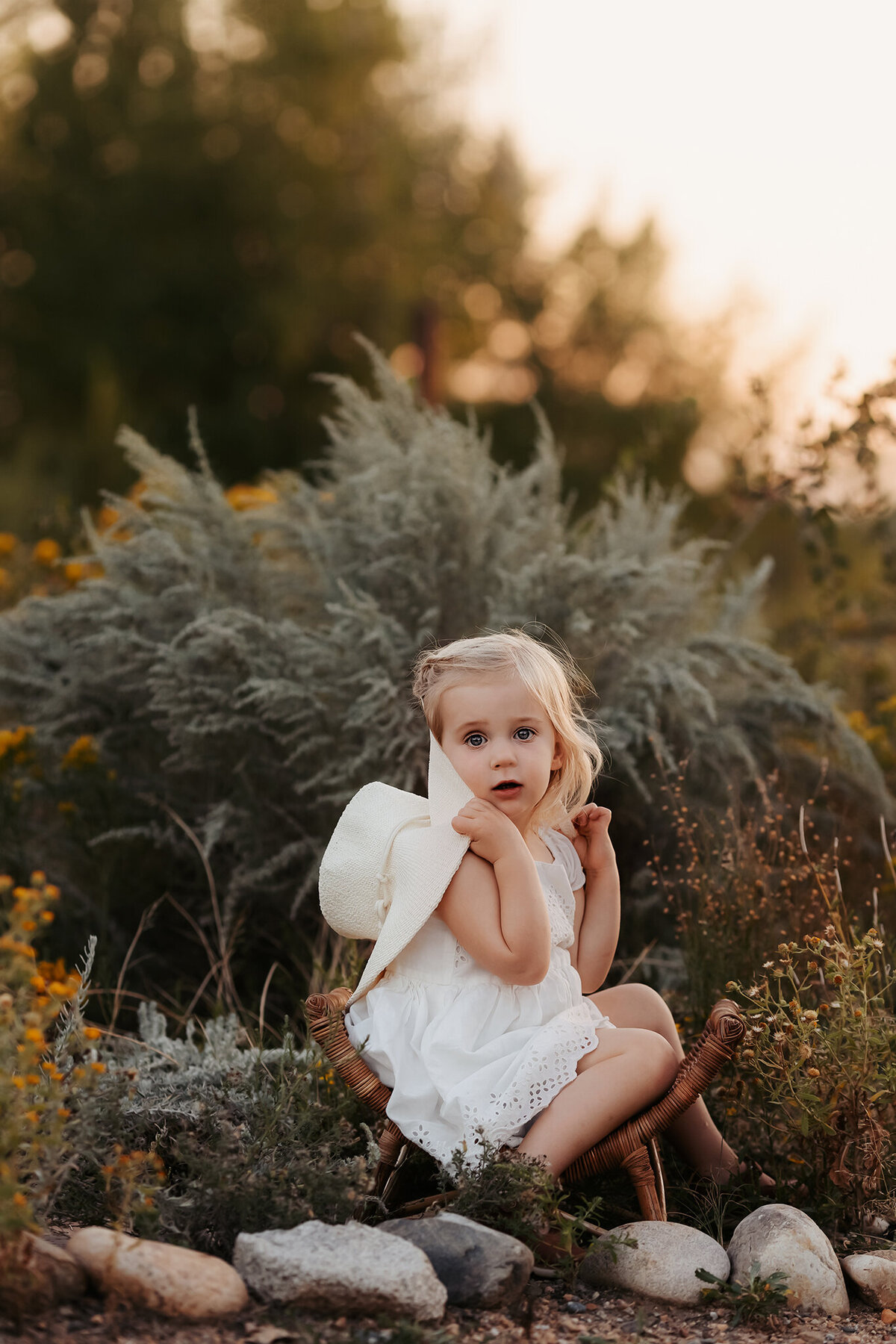 little girl in a cute chair smiling during their denver family photos