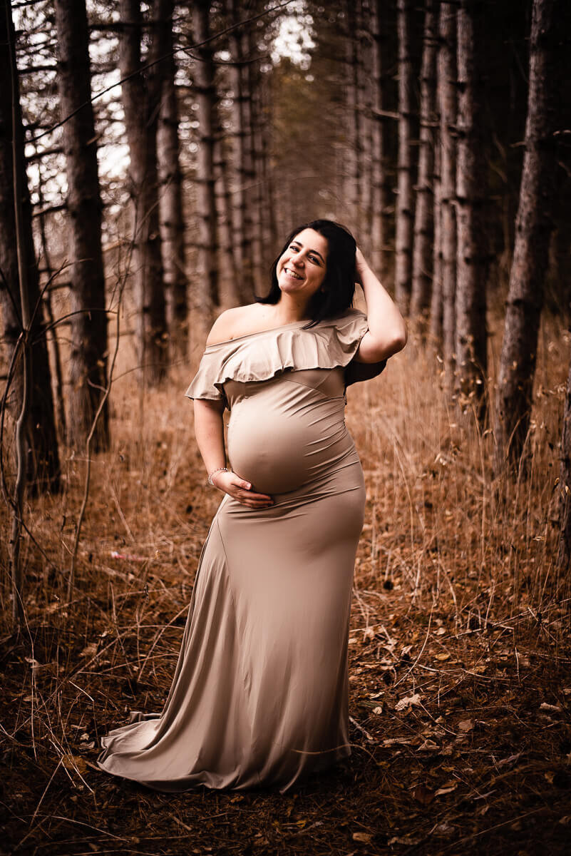 Excited pregnant mom to be posing in forest in Toronto for maternity photos