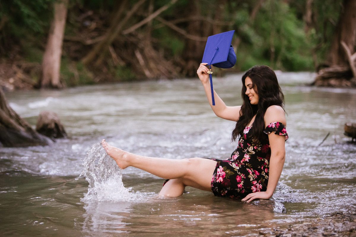 high school senior girl kicking her feet in river water by San Antonio senior photographer
